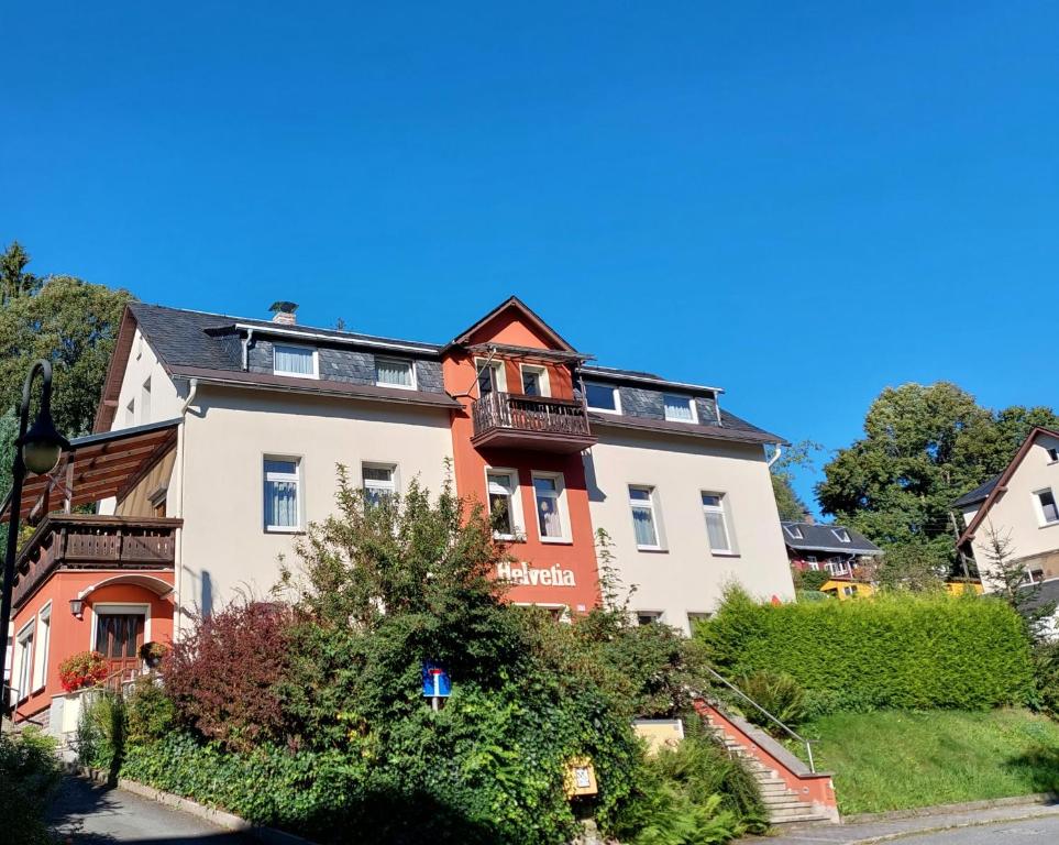 in einem großen weißen und orangefarbenen Gebäude mit Balkon in der Unterkunft Villa Helvetia in Bad Elster