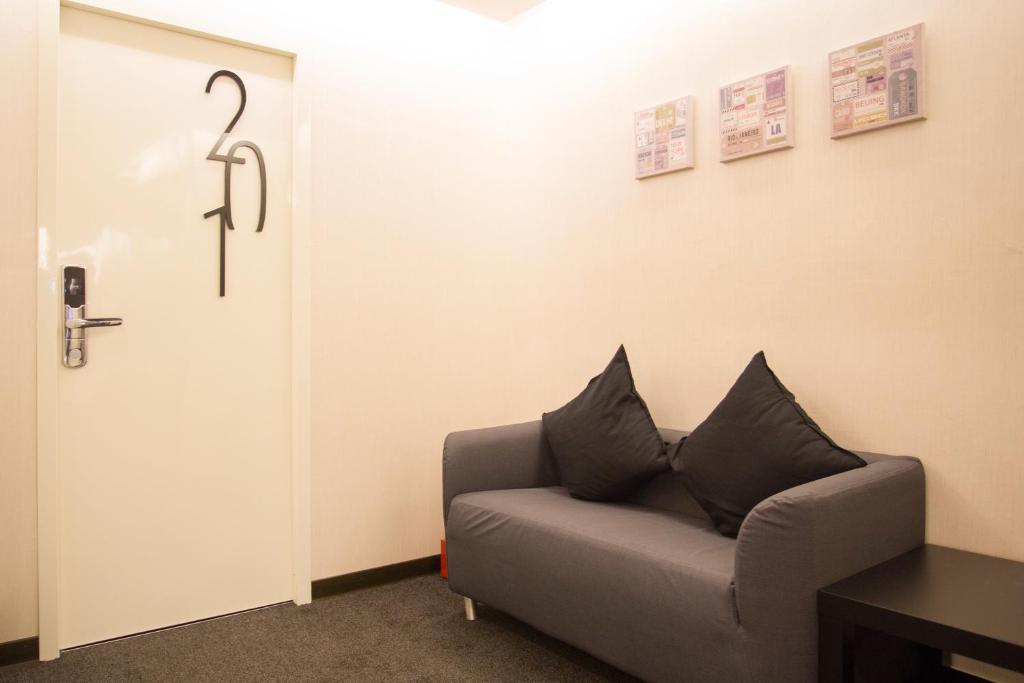 a living room with a couch next to a door at Fun Inn Taipei Hostel in Taipei