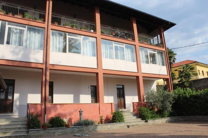 ein großes rot-weißes Gebäude mit einem Balkon in der Unterkunft IL VECCHIO CAMINO in Baraggia di Boca