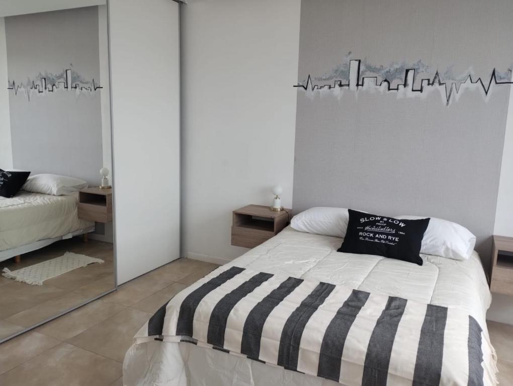 a bedroom with a bed with a black and white striped blanket at Paisaje 1 in Comodoro Rivadavia