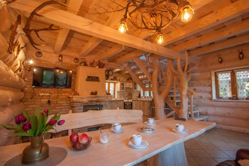 uma cozinha de chalé de madeira com uma grande mesa de madeira em Chatka Ustrzyki em Ustrzyki Dolne