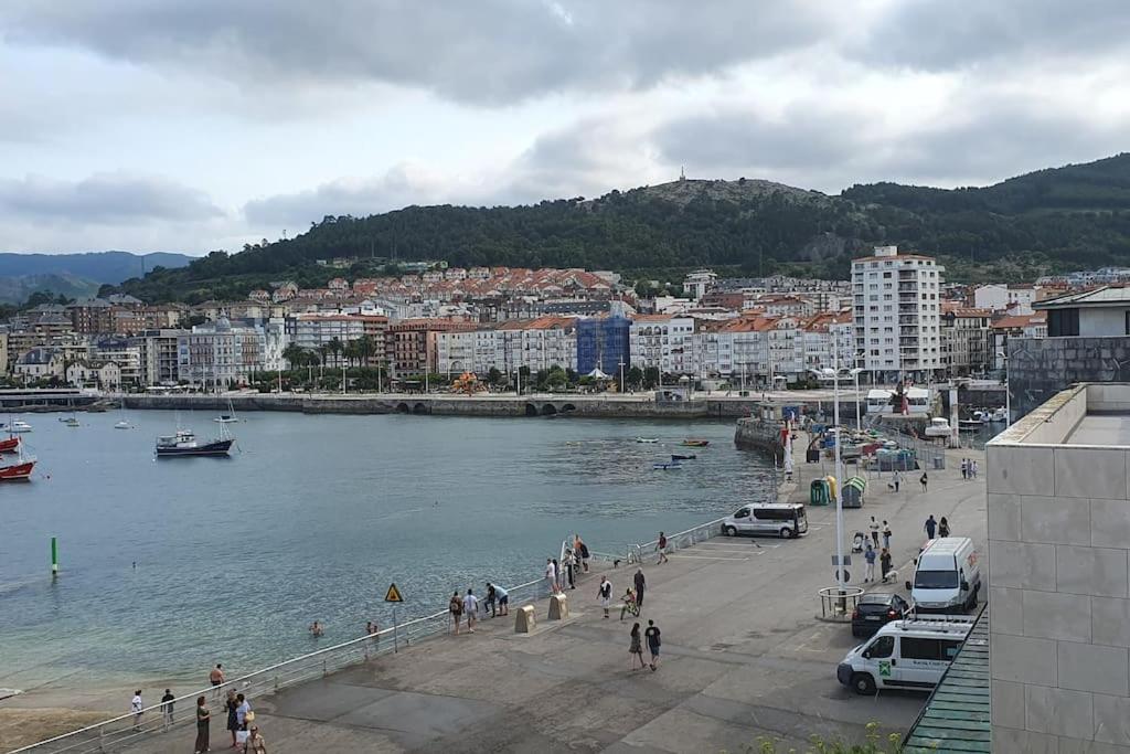 een groep mensen die langs een rivier lopen met een stad bij Apartamento en el casco viejo de Castro Urdiales in Castro-Urdiales