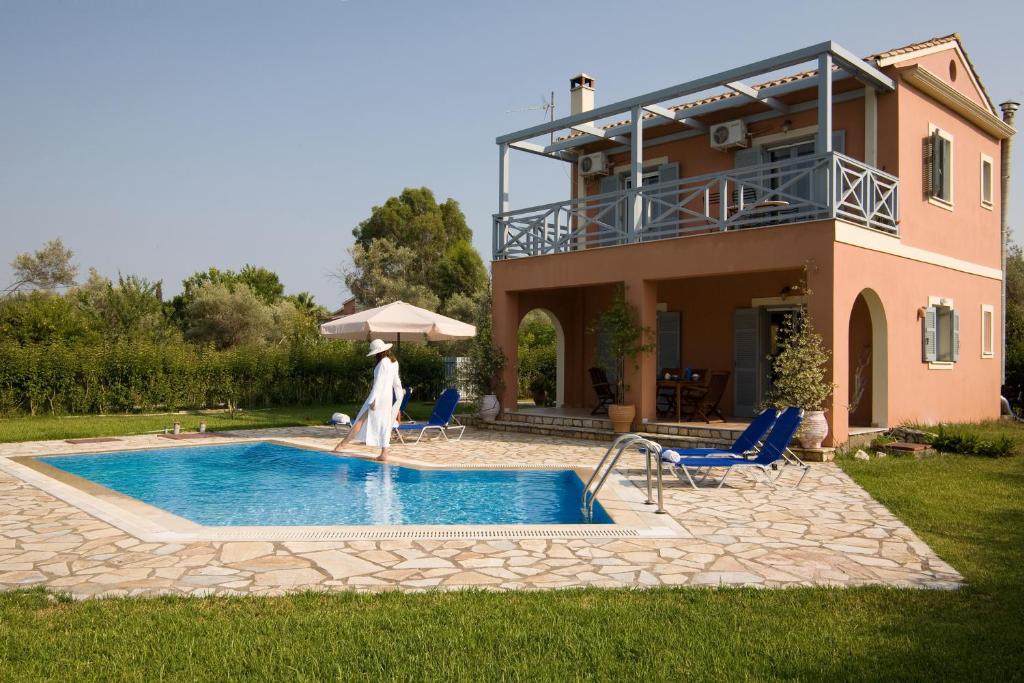 a villa with a swimming pool in front of a house at Villa Simeoni in Lefkada