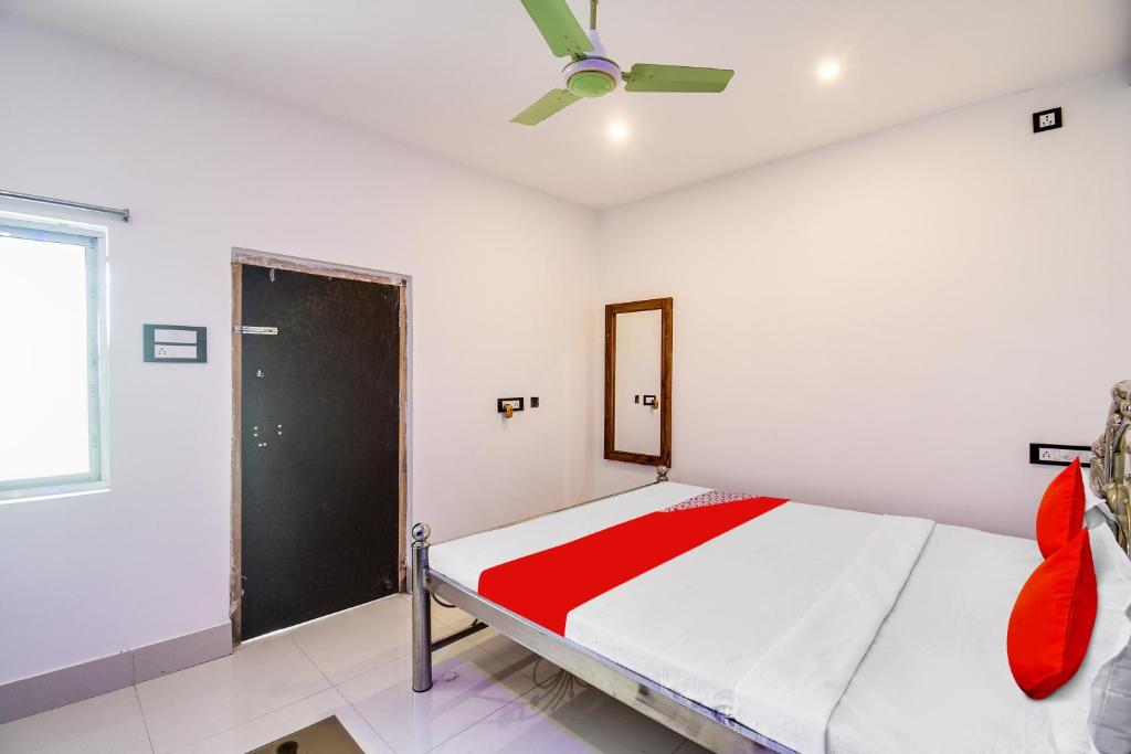 a bedroom with a bed and a ceiling fan at OYO Flagship Mango Leaf Hotel & Restaurant in Baharampur