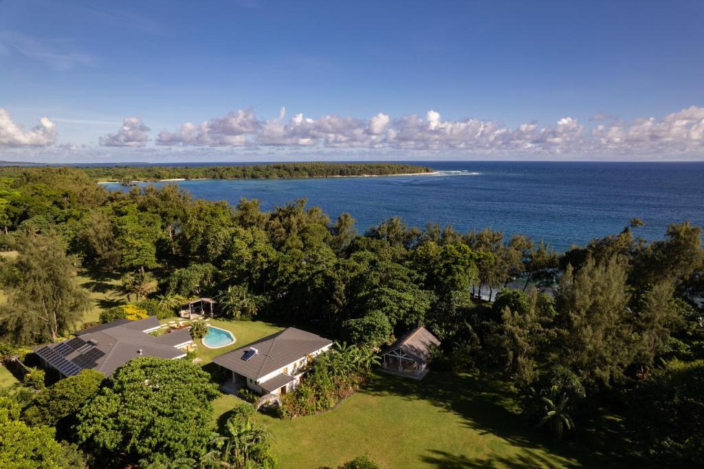 een luchtzicht op een huis met de oceaan op de achtergrond bij Nakatumble - Luxury Sustainable Villa with Farm in Pangona