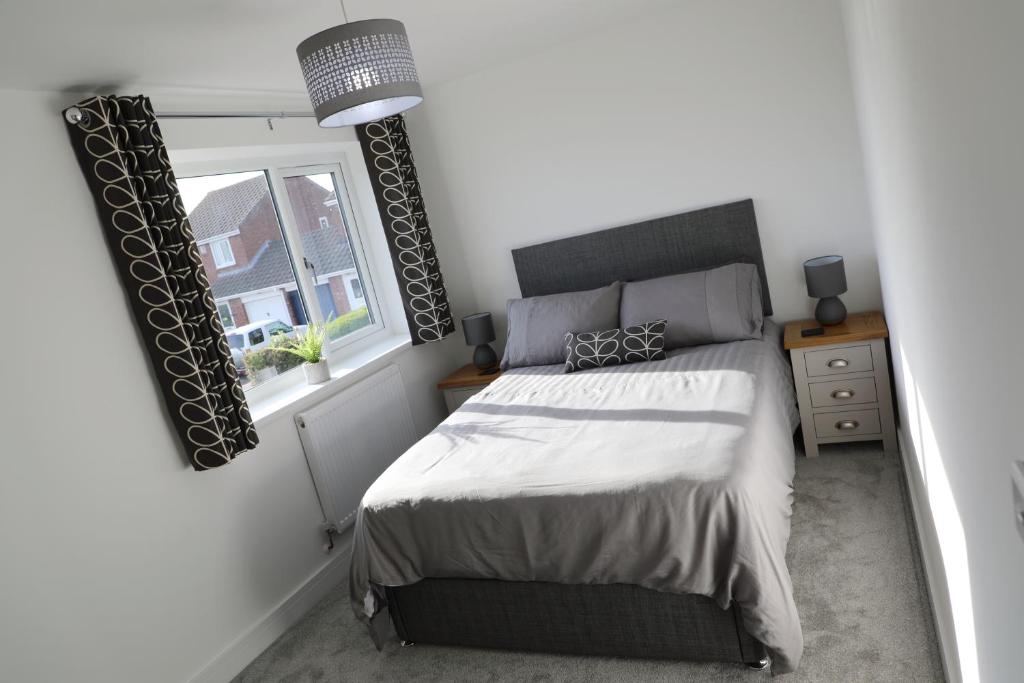 ein Schlafzimmer mit einem großen Bett und einem Fenster in der Unterkunft Modern, Two Double Bedroom House with Free Parking in Chepstow