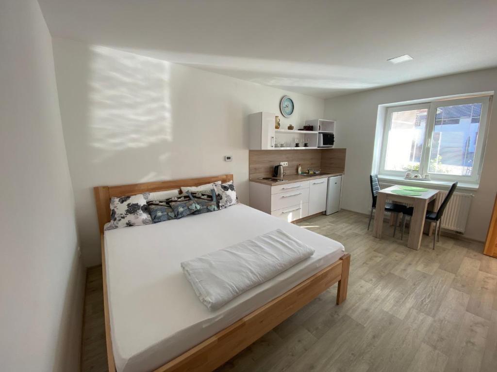 um quarto com uma cama, uma mesa e uma cozinha em Útulná garsonka v přírodě pro 2 osoby em Jihlava