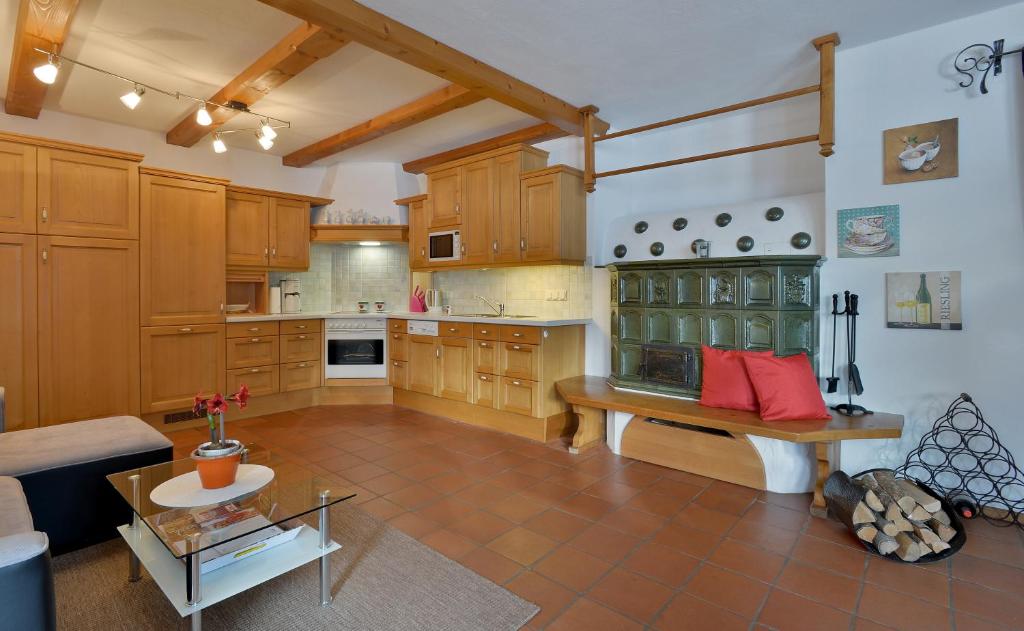 キルヒベルク・イン・チロルにあるAppartement Sybille by NV-Appartementsの木製キャビネットとテーブル付きの広いキッチンが備わります。
