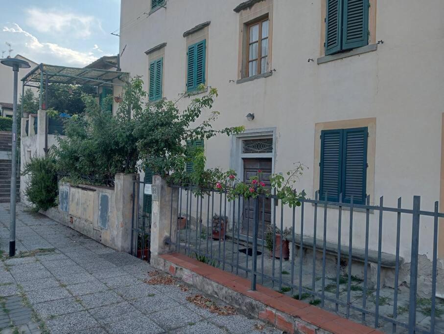 einen Zaun vor einem weißen Gebäude in der Unterkunft Private room at the Casa delle Volte in Figline Valdarno
