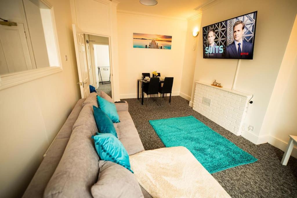 a living room with a couch and a tv at Spacious Sea-View Flat w SmartTV in Lowestoft