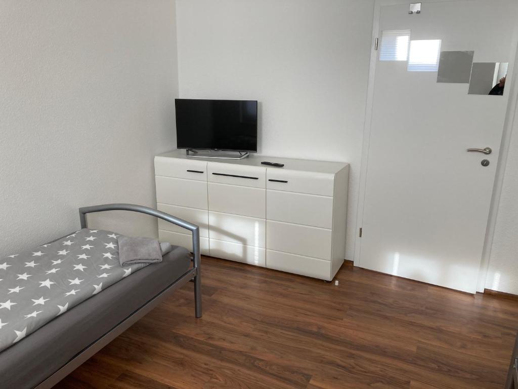 um quarto com uma cama e uma televisão numa cómoda em Ferienwohnungen Funke für Monteure in Apolda em Apolda