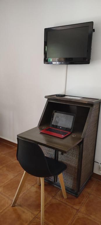 a desk with a laptop and a tv on a wall at Chambre d&#39;hôte Amouratcha in Fabrègues