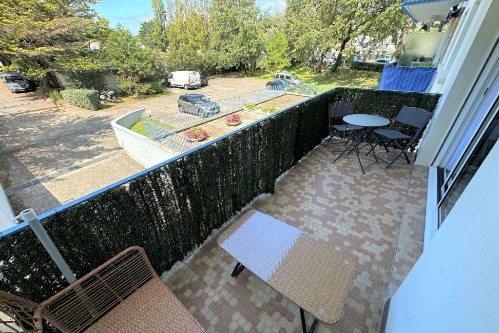 a balcony with a table and chairs and a boat at Studio with balcony - 2 min beach and AquaBaule in La Baule