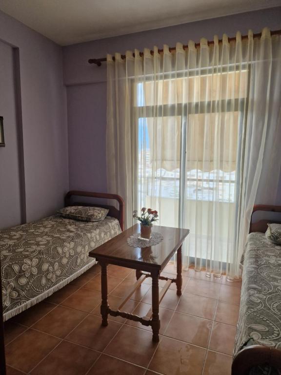 Habitación con 2 camas y mesa con ventana en Homemaker, en Berat