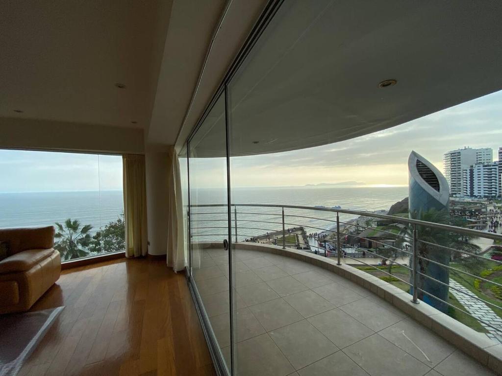 Apartamento Vista al Mar في ليما: غرفة مع شرفة مطلة على المحيط