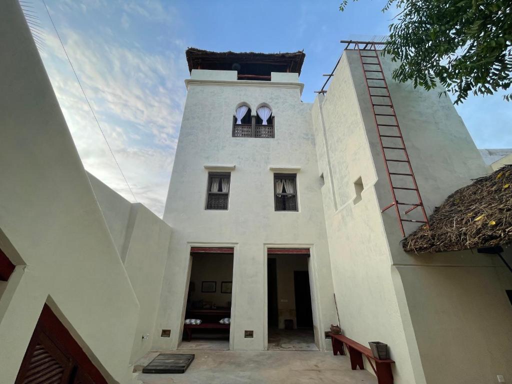 a white building with a tower with two windows at Umma House in Lamu