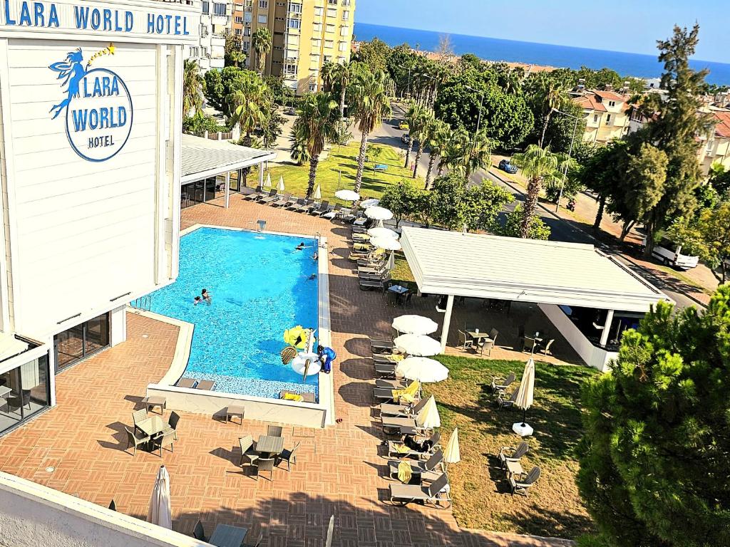 an overhead view of a swimming pool with chairs and umbrellas at Lara World Hotel in Antalya