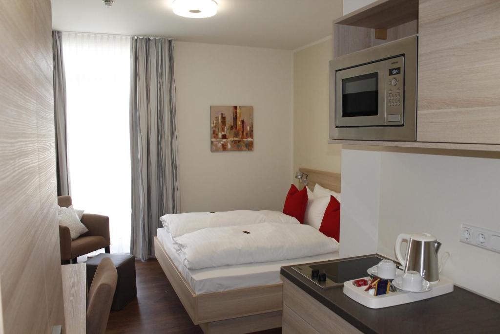ein Hotelzimmer mit einem Bett und einer Mikrowelle in der Unterkunft Prime 20 Serviced Apartments in Frankfurt am Main