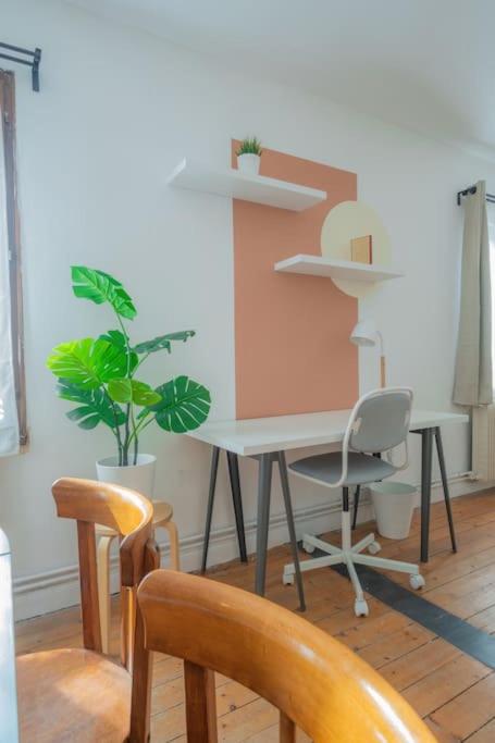 a room with a desk with chairs and a plant at Spacy Rock in Reims