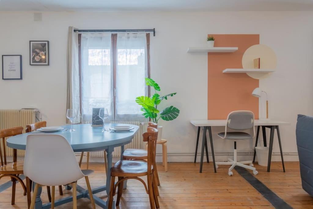 a dining room with a blue table and chairs at Spacy Rock in Reims