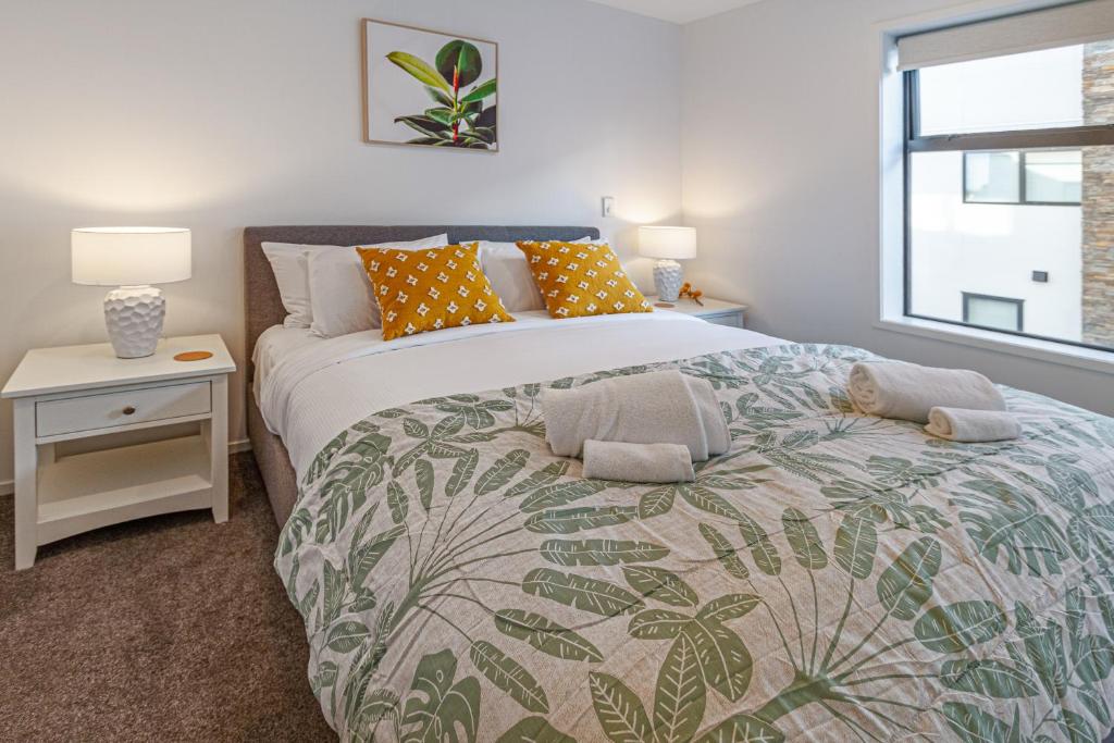 Un dormitorio con una cama grande y una ventana en Vibrant City Abode - 2 bed 2 bath, en Christchurch