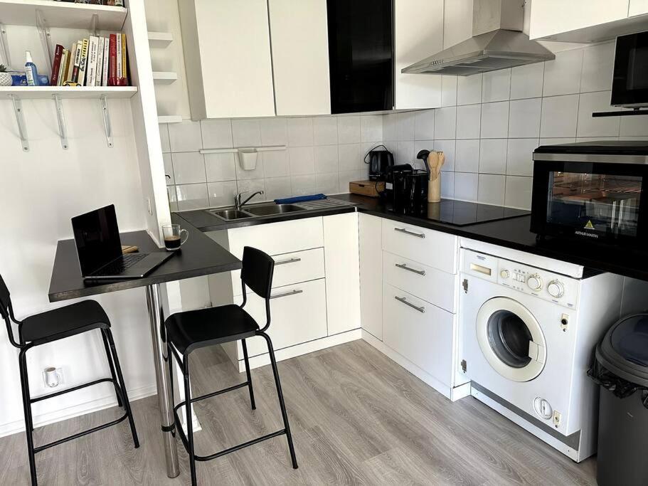 a kitchen with a washing machine and a table and chairs at Studio JadOr gare du Bourget Paris aeroport Charles de Gaulle in Le Bourget