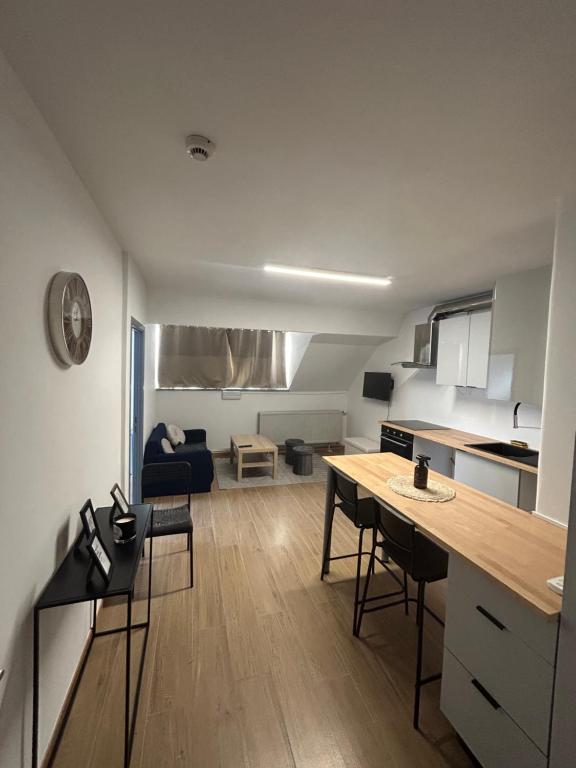 Elegance & Comfort Brand New Apartment near to Atomium في بروكسل: مطبخ وغرفة معيشة مع طاولة وكراسي