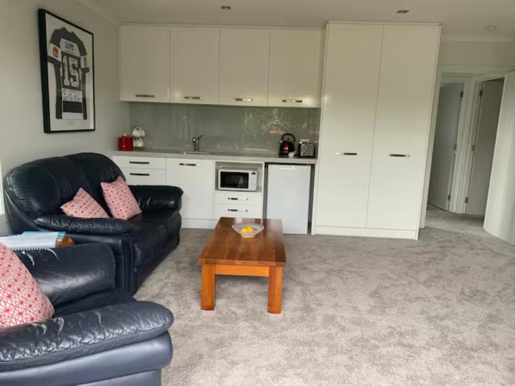 een woonkamer met een bank en een salontafel bij HotelSuse in Napier