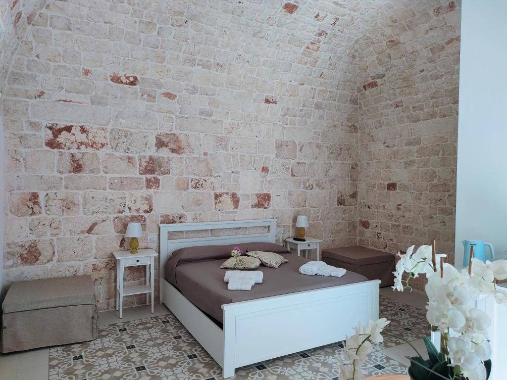 sypialnia z łóżkiem i ceglaną ścianą w obiekcie Dimora Storica Il Tiglio w mieście Castellana Grotte