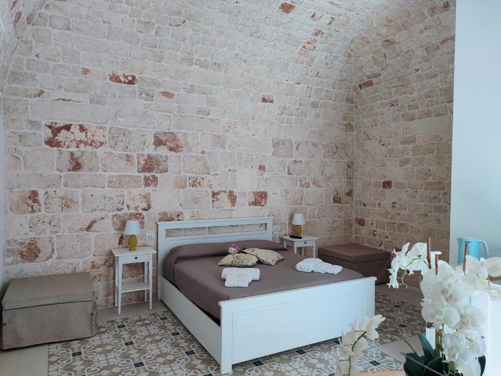 a bedroom with a bed and a brick wall at Dimora Storica Il Tiglio in Castellana Grotte
