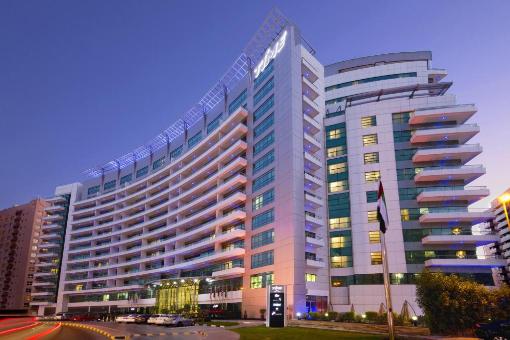 a large building with lights on in a city at TIME Oak Hotel & Suites in Dubai