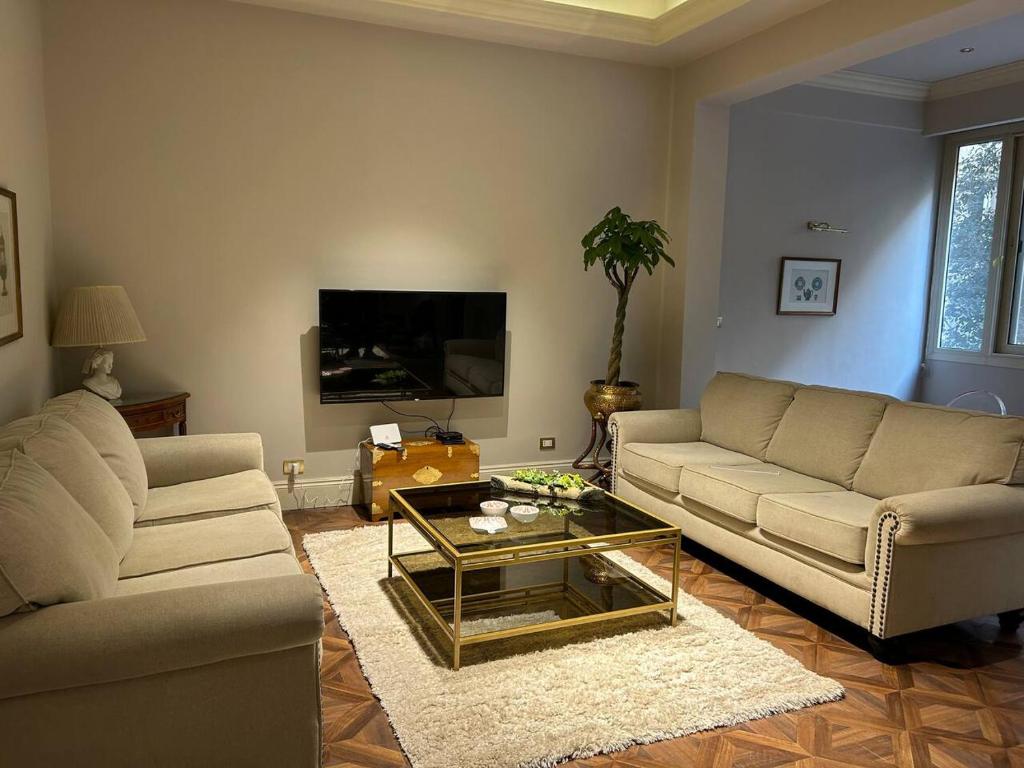 a living room with two couches and a coffee table at Charming luxurious 2 bedroom apartment in zamalek in Cairo