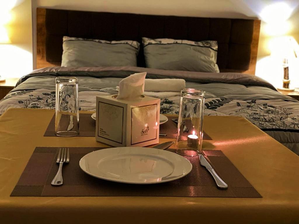 uma mesa com um prato e um guardanapo numa cama em Petra Everest Hostel em ‘Ayn Amūn