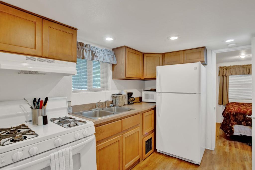 a kitchen with wooden cabinets and a white refrigerator at Fig Cabin in Fredericksburg