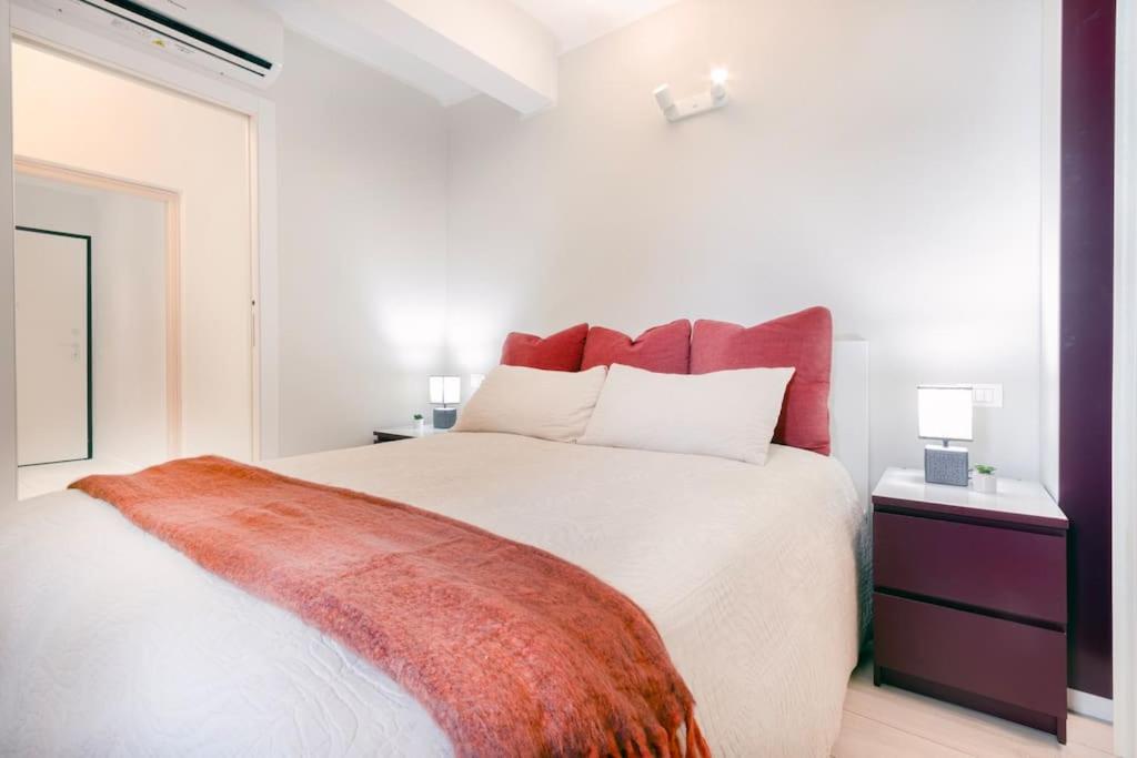 una camera da letto con un grande letto bianco con cuscini rossi di Red Ferrari House - City center a Modena