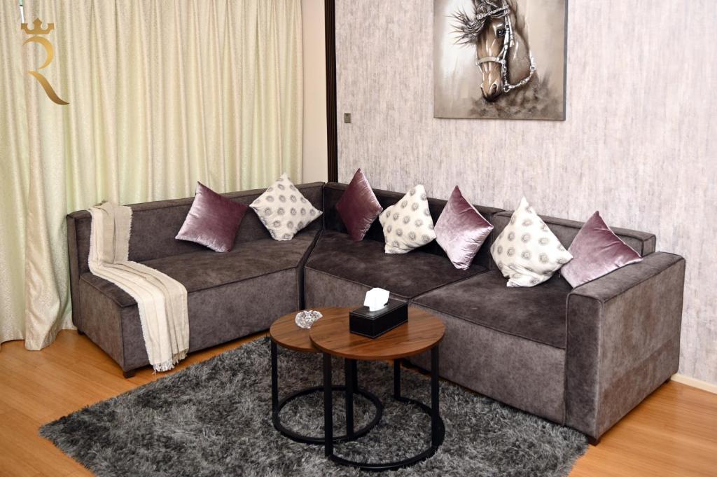 a living room with a couch with pillows on it at Your 2BR Luna Retreat with Beach Access in Al Rahba in Abu Dhabi