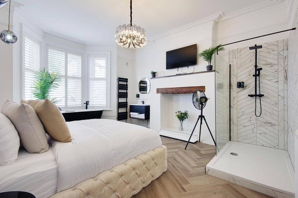 a white bedroom with a bed and a fireplace at Mount Lodge in Bournemouth