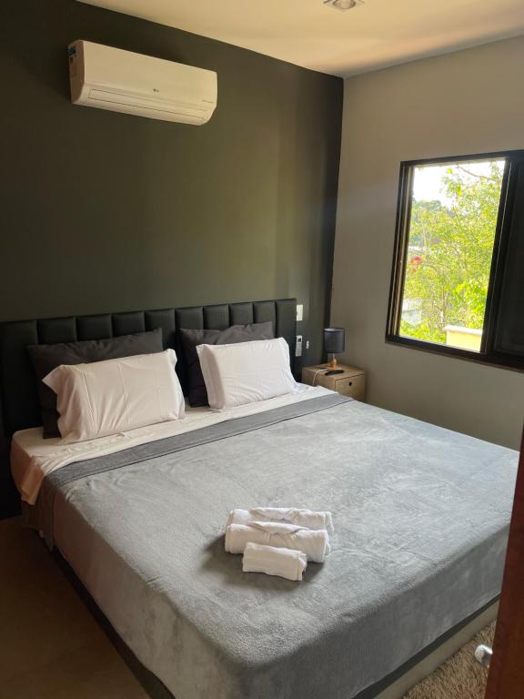 1 dormitorio con 1 cama grande y 2 toallas. en STUDIO perfeito na montanha, en Río de Janeiro