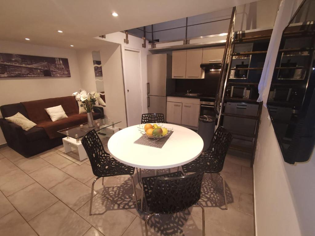 une cuisine et un salon avec une table et des chaises dans l'établissement Duplex 3 pièces 4 couchages au Suquet à 2 mn à pied du port de Cannes, du centre, de la mer et du palais des festival, à Cannes