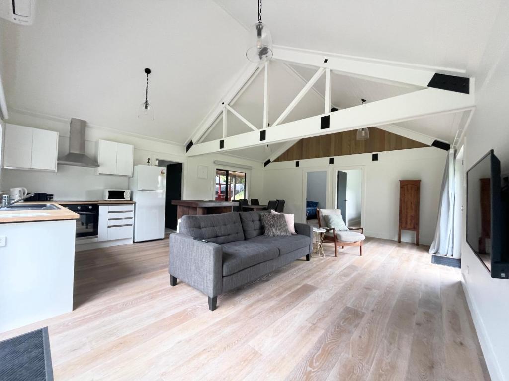 a living room with a couch and a kitchen at Stunning 2 bedroom Guesthouse in Tamahere