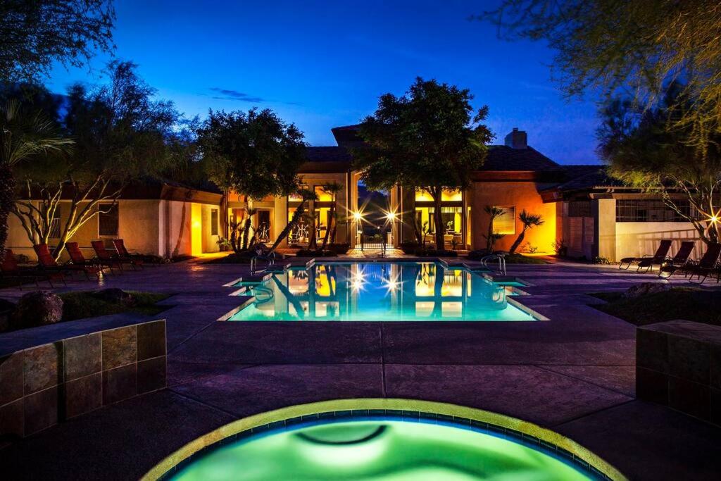a house with a swimming pool at night at Luxury Vacation Rentals by Meridian CondoResorts in Scottsdale