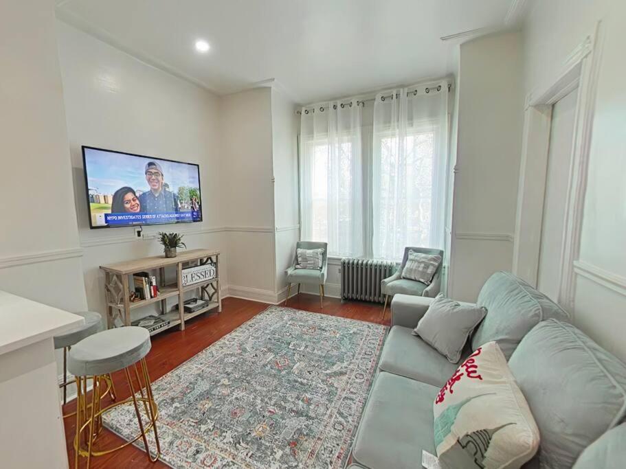 ein Wohnzimmer mit einem Sofa und einem Flachbild-TV in der Unterkunft Elegant 3Br Apt Yankee stadium in Melrose