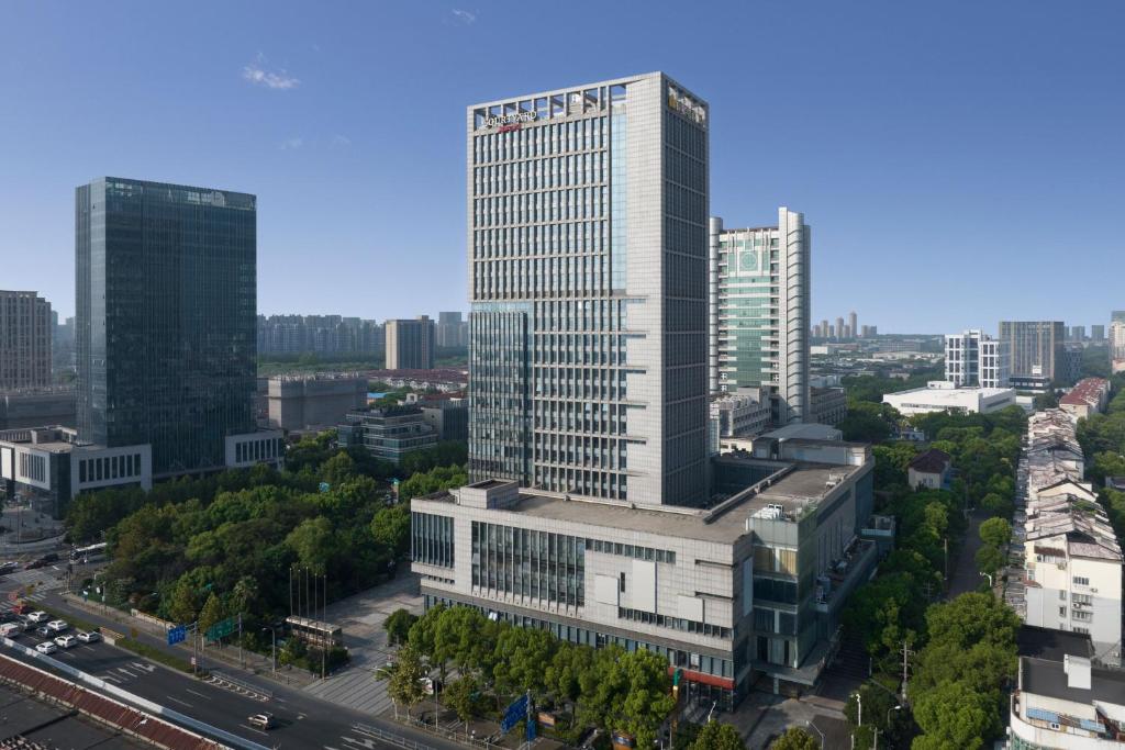 eine Luftansicht eines hohen Gebäudes in einer Stadt in der Unterkunft Courtyard by Marriott Shanghai Jiading in Jiading