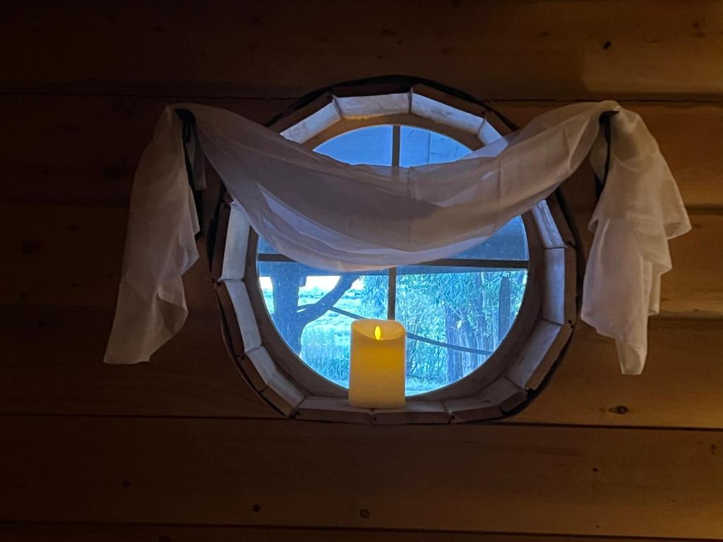 una finestra rotonda con una candela in una stanza di The Gratitude Homestay ad Alamosa