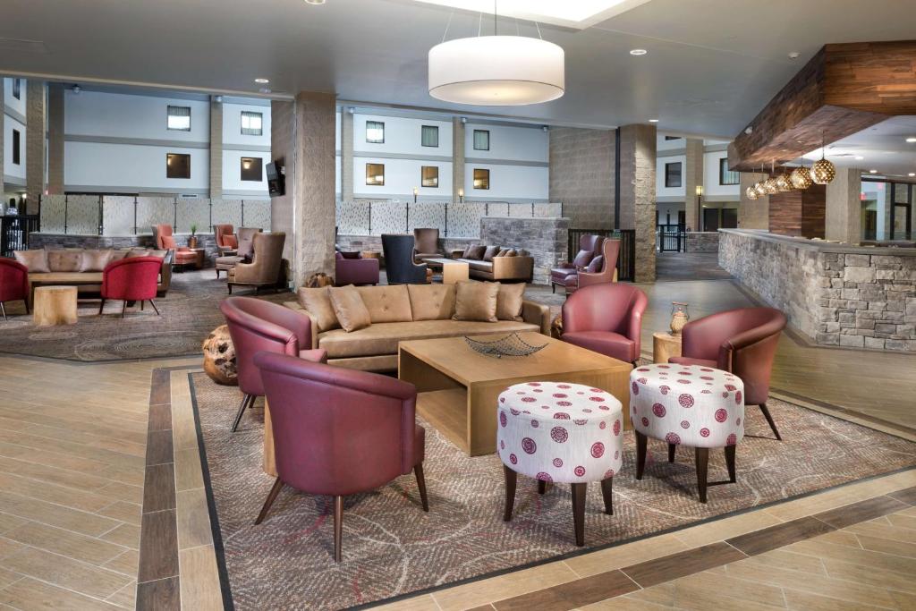 a lobby with a couch and a table and chairs at DoubleTree by Hilton Lawrence in Lawrence