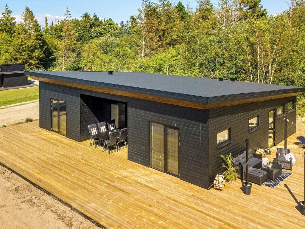 a modular home with a wooden deck at Holiday home Løgstør IX in Løgstør