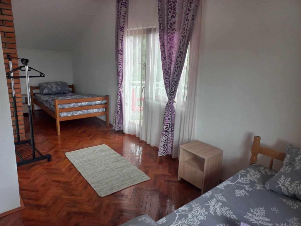 1 dormitorio con cama, mesa y ventana en Vikendica Savić, en Šipovo