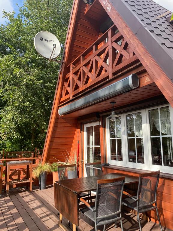 eine Holzterrasse mit einem Tisch und Stühlen auf einem Haus in der Unterkunft Kamień na Kaszubach in Kamień