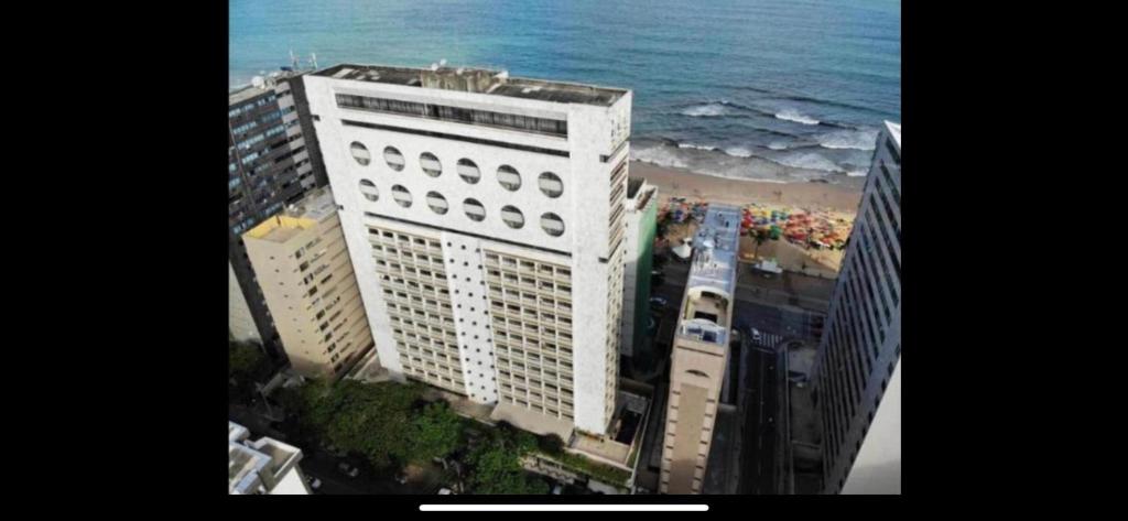 a tall white building next to the ocean at FLAT Praia Boa Viagem in Recife