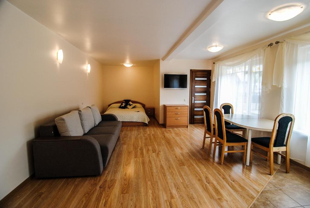 ein Wohnzimmer mit einem Sofa, einem Tisch und einem Bett in der Unterkunft Apartamentų nuoma in Palanga